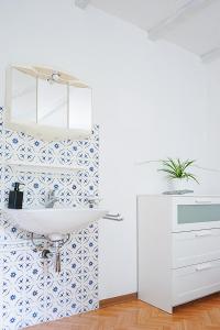 a bathroom with a white sink and blue and white tiles at Ristorante Locanda Zott in Valle Onsernone in Vergeletto