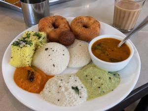 a plate of food with dip and donuts and dipping sauce at Younis Guest house in Srinagar