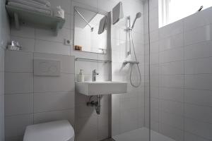 a bathroom with a shower and a sink and a toilet at DuinHotel Texel in De Koog +53 photos