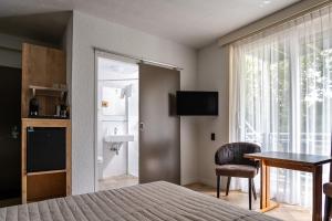 a bedroom with a bed and a table and a window at DuinHotel Texel in De Koog