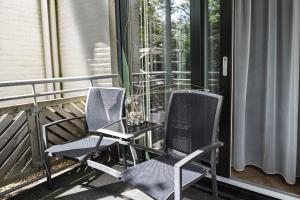 two chairs sitting on a porch next to a window at DuinHotel Texel in De Koog