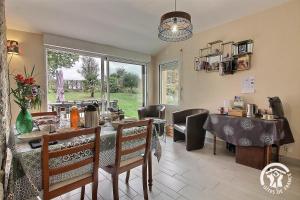 a dining room with a table and chairs and a window at La croix au roi in Lamballe Armor +37 photos