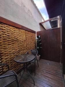a patio with a table and chairs on a wooden deck at Pousada Alecrim Dourado in Paraty