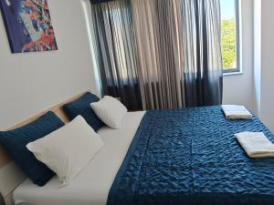a bedroom with a bed with a blue blanket and a window at IGGY in Malinska +96 photos