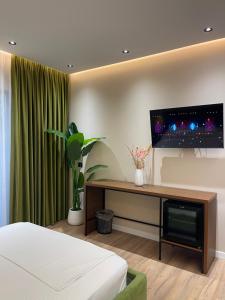 a bedroom with a bed and a flat screen tv at Olivium Rooms in Vlorë