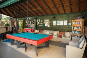 a pool table in a room with chairs and a book shelf at Life Apart in Marmaris