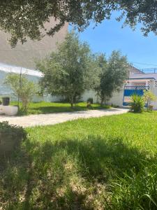 a grassy yard with trees and a building at 3 bedroom Villa with garden in Ez Zahra