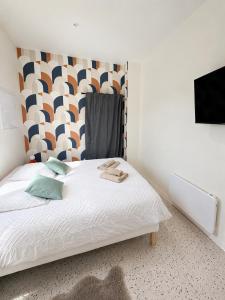 a bedroom with a white bed with a headboard at Appartement Central avec Jacuzzi Privé I Strasbnb in Strasbourg