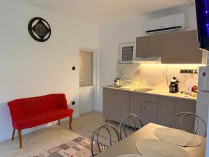 a kitchen with a red chair next to a counter at Casa Alba - Tasnad in Tăşnad