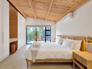 a bedroom with a large white bed with a wooden ceiling at Lily of the Valley - Higgovale in Cape Town +54 photos