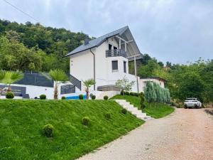 a house on a hill with a car parked in front at Residence La Femme in Tuzla