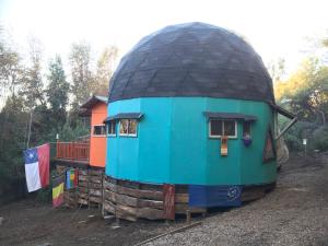 a dome house sitting on a pile of logs at Chakana Newen Refugio in San Clemente +3 photos