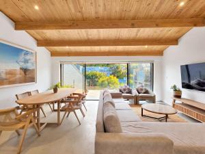 a living room with a wooden ceiling and a table and chairs at Lily of the Valley - Higgovale in Cape Town