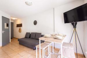 a living room with a table and a couch at Valras-Loc - T2 Piscine Terrasse in Valras-Plage