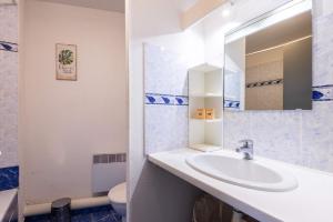 a bathroom with a sink and a mirror and a toilet at Valras-Loc - T2 Piscine Terrasse in Valras-Plage