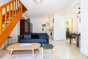 a living room with a blue couch and a table at Valras-Loc Maison T3 in Valras-Plage