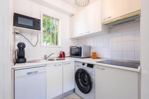 a kitchen with a washing machine and a microwave at Valras-Loc Maison T3 in Valras-Plage +15 photos