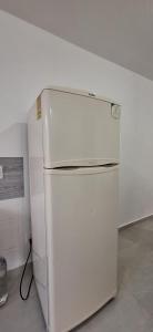 a white refrigerator in a kitchen with a hose at Casa Las Luces in Nanacamilpa