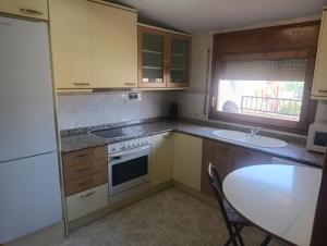 a kitchen with a table and a sink and a stove at APARTAMENTO QUINTO in Valderrobres