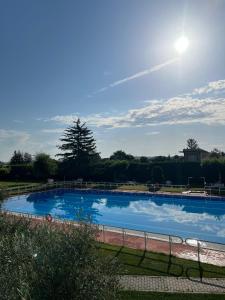 a large blue swimming pool with the sun in the sky at Hotel Valjunco in Valencia de Don Juan