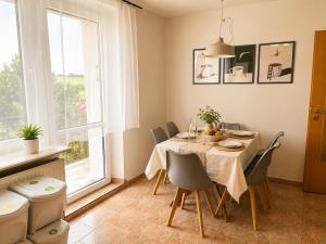 a dining room with a table and chairs and a window at Nine to Trail Apartment in Wielka Wieś
