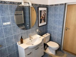 a bathroom with a sink and a toilet and a mirror at Nine to Trail Apartment in Wielka Wieś +13 photos