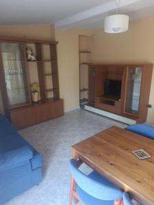 a living room with a table and a blue couch at APARTAMENTO QUINTO in Valderrobres