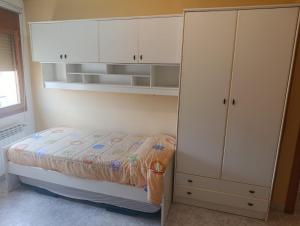 a bedroom with a bed and a white cabinet at APARTAMENTO QUINTO in Valderrobres