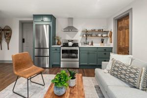 a living room with a couch and a kitchen at Luxe Vermont Duplex in Stowe