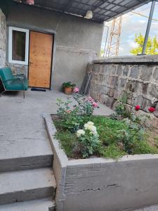 a patio with a chair and flowers in front of a building at Comfort House in Balaovit