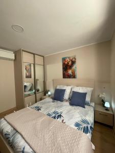a bedroom with a large bed with blue pillows at Przystań przy Krzywej in Dziwnów
