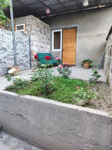 a patio with a chair and flowers in front of a door at Comfort House in Balaovit