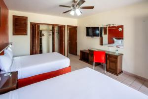 ein Hotelzimmer mit zwei Betten und einem Schreibtisch in der Unterkunft Villas del Sol Hotel & Bungalows in Oaxaca de Juárez