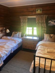 a bedroom with two beds and a window at Knutehytta in Kongsberg