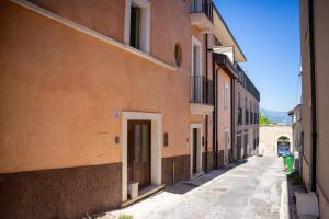 an alley with buildings and a door on the side at 99 Rooms in LʼAquila