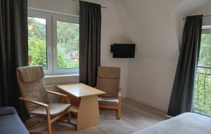 a room with two chairs and a table and a window at Przy Lesie Apartamenty Pokoje Parking in Pobierowo