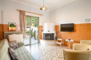 a living room with a fireplace and a tv at Giorgos House in Nafpaktos