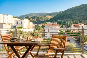 a table and chairs on a balcony with a view at Giorgos House in Nafpaktos