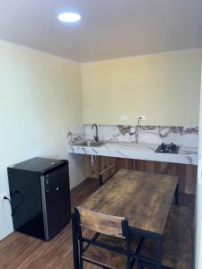 a kitchen with a wooden table and a sink at Villa Clarice in Bonao