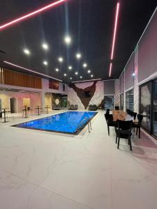 a large pool in a room with a table and chairs at Vila Elezi 2 in Tirana