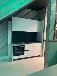 a kitchen with white cabinets and a stove at Vila Elezi 2 in Tirana