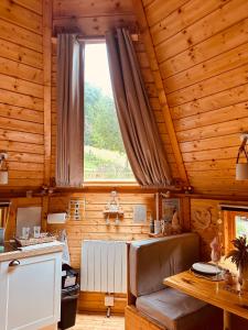a kitchen in a log cabin with a window at Cabane Kota Désiré, bain nordique in Saint Die