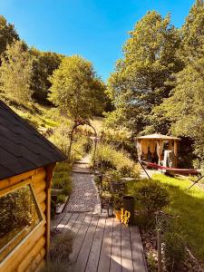 a wooden deck with a gazebo in a garden at Cabane Kota Désiré, bain nordique in Saint Die