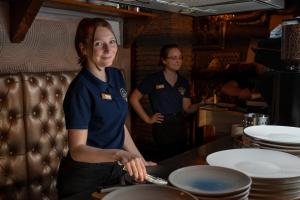 two people standing in a kitchen preparing food at Hotel The Stamp in Den Bosch