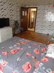 a bed with pink flowers on it in a bedroom at Апартамент in Razgrad