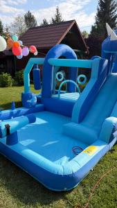 a blue inflatable bounce house on the grass at Pokoje U Stefanów in Królowy Most