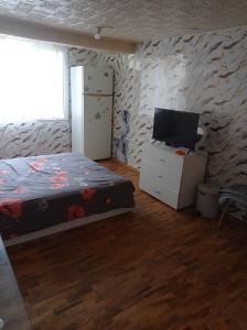a bedroom with a bed and a flat screen tv at Апартамент in Razgrad +2 photos