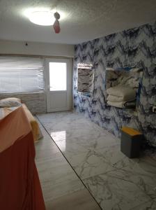 a room with a stone wall with a bed and a window at Апартамент in Razgrad