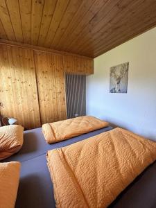 two beds in a bedroom with wooden walls and wooden ceilings at Ferienhaus Kühlwein in Bad Goisern