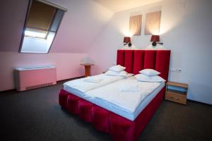 a bedroom with a large bed with a red headboard at Vila Aura in Sovata
